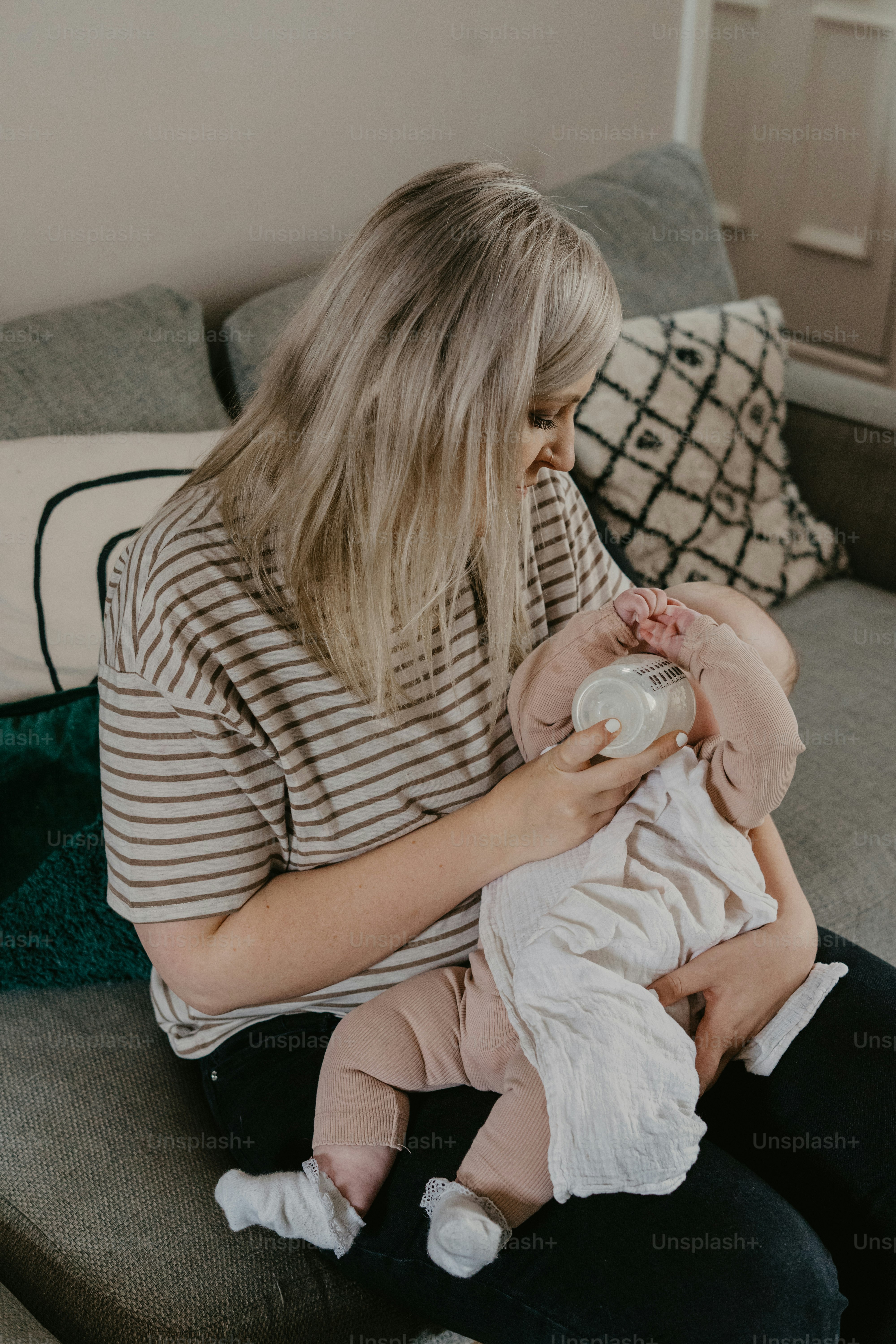 a woman sitting on a couch holding a baby