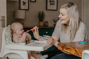 Eine Frau füttert ein Baby mit einer Zahnbürste