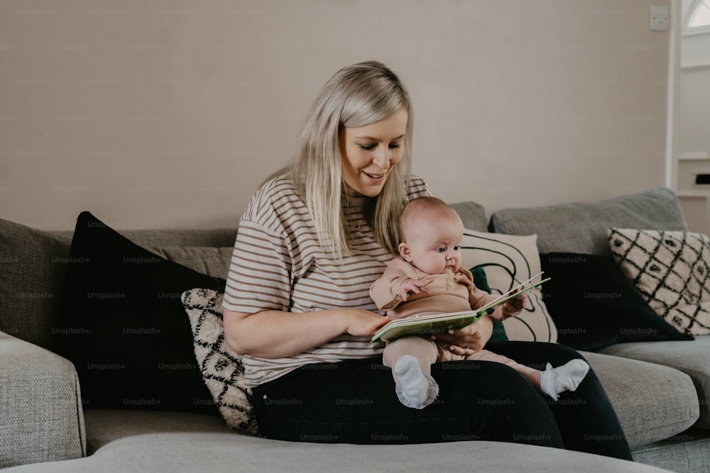 a woman sitting on a couch holding a baby