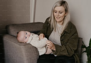 Eine Frau, die auf einer Couch sitzt und ein Baby hält
