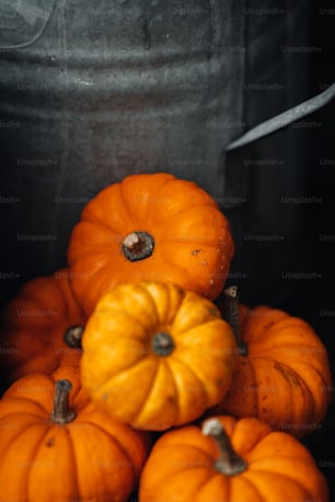 a bunch of pumpkins sitting on top of a bucket