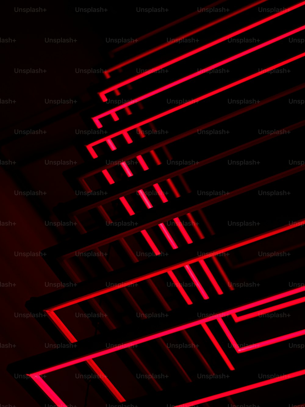 a row of red neon lights in a dark room