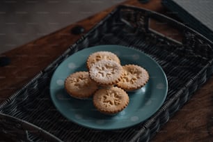 um prato azul coberto com pequenos biscoitos em cima de uma mesa