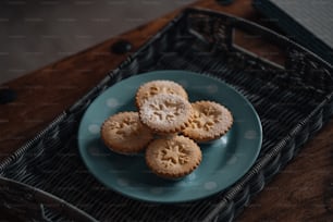 a blue plate topped with small cookies on top of a table