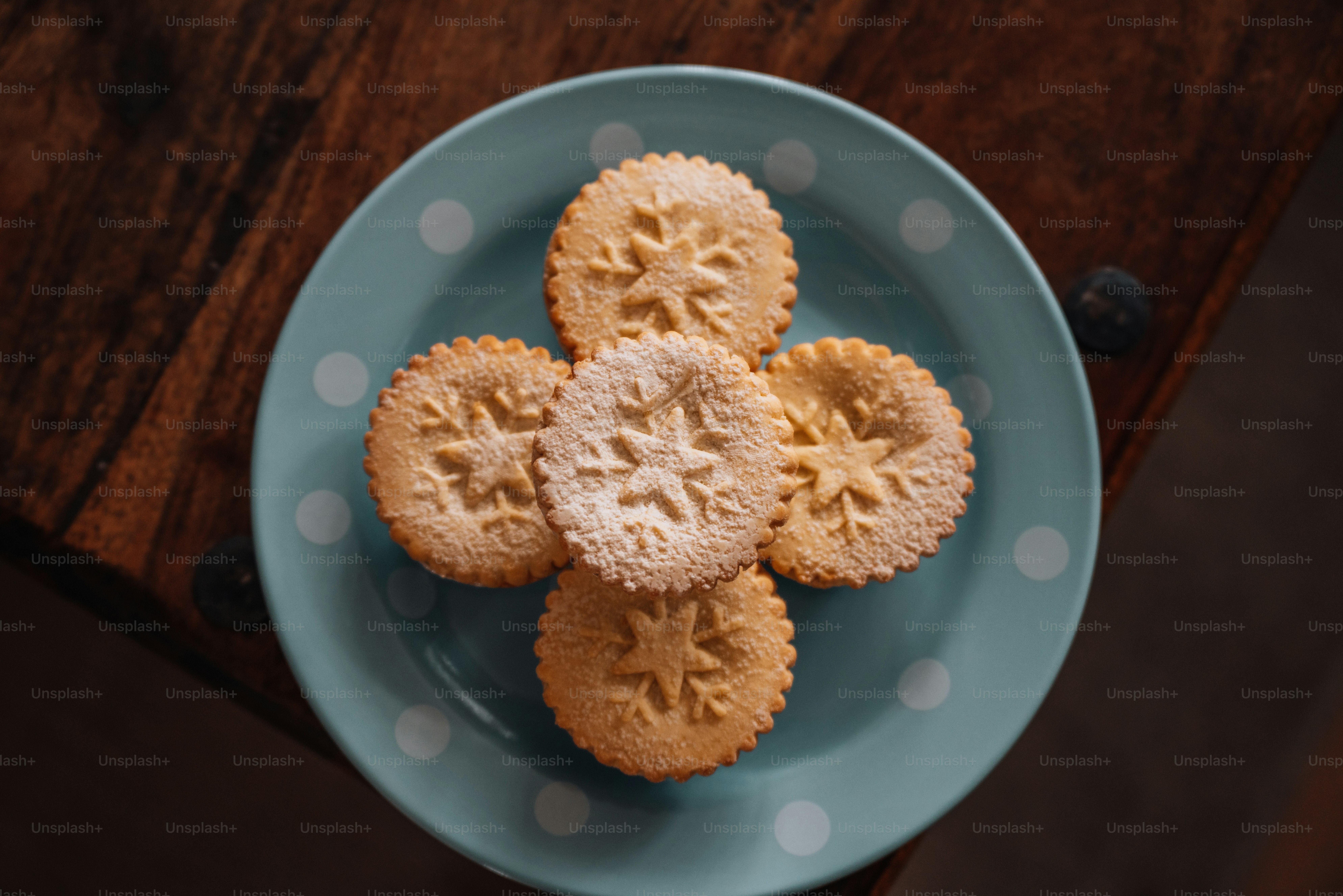 a blue plate topped with four cookies on top of a wooden table