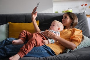 a woman sitting on a couch holding a baby