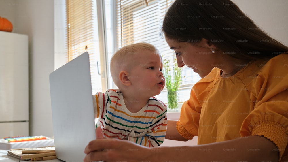 Eine Frau und ein Kind schauen auf einen Laptop