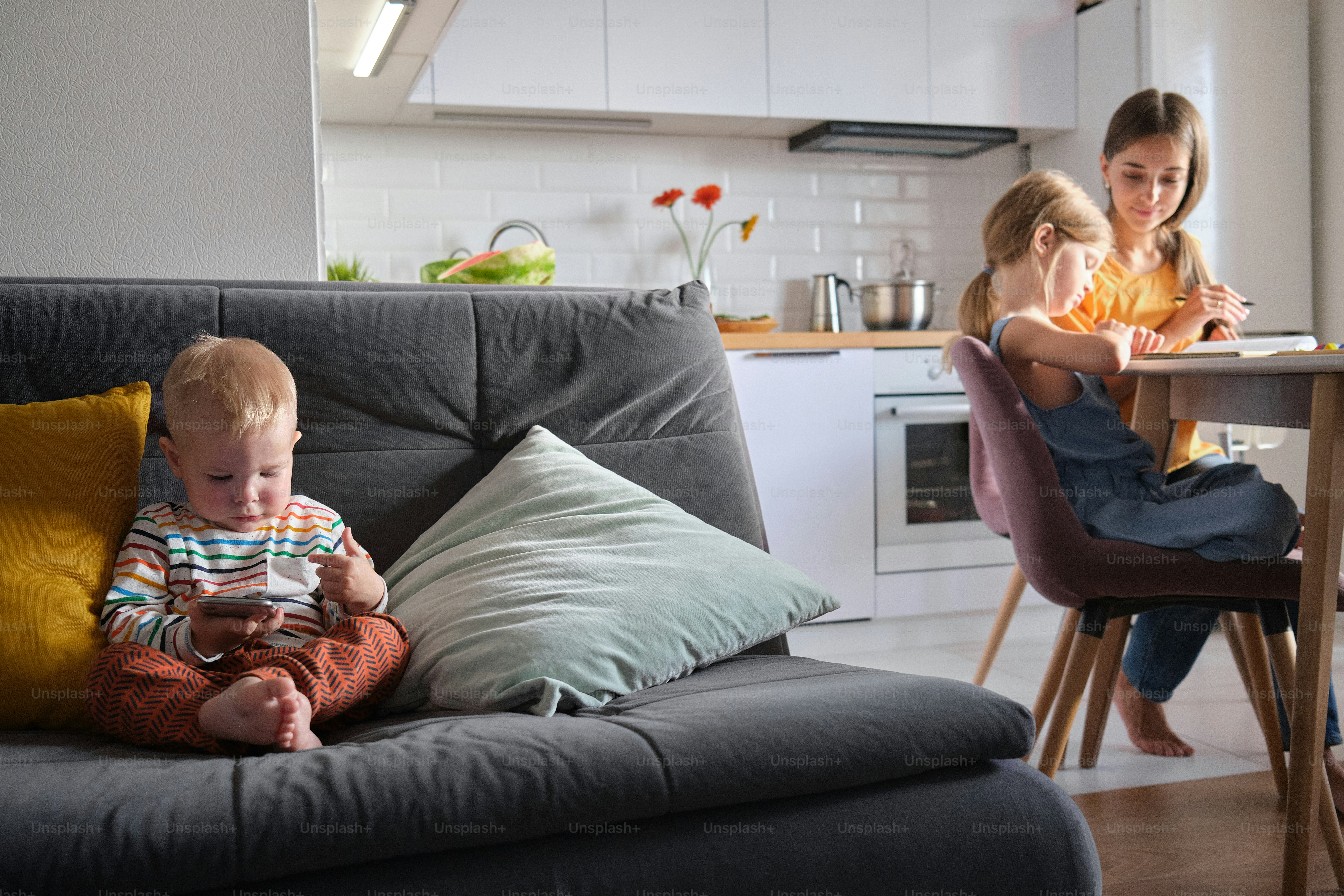 女性の隣のソファに座っている小さな男の子