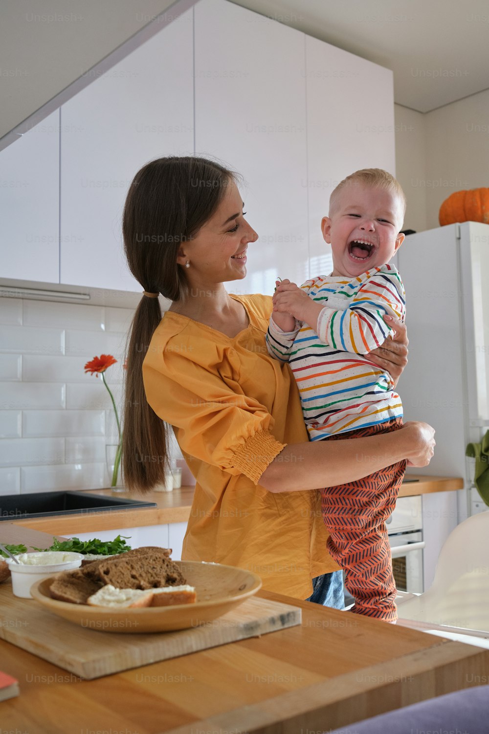 a woman holding a baby in a kitchen