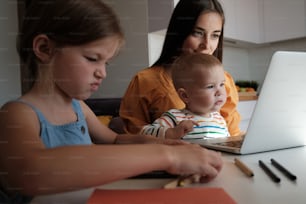 Une femme et un enfant assis devant un ordinateur portable