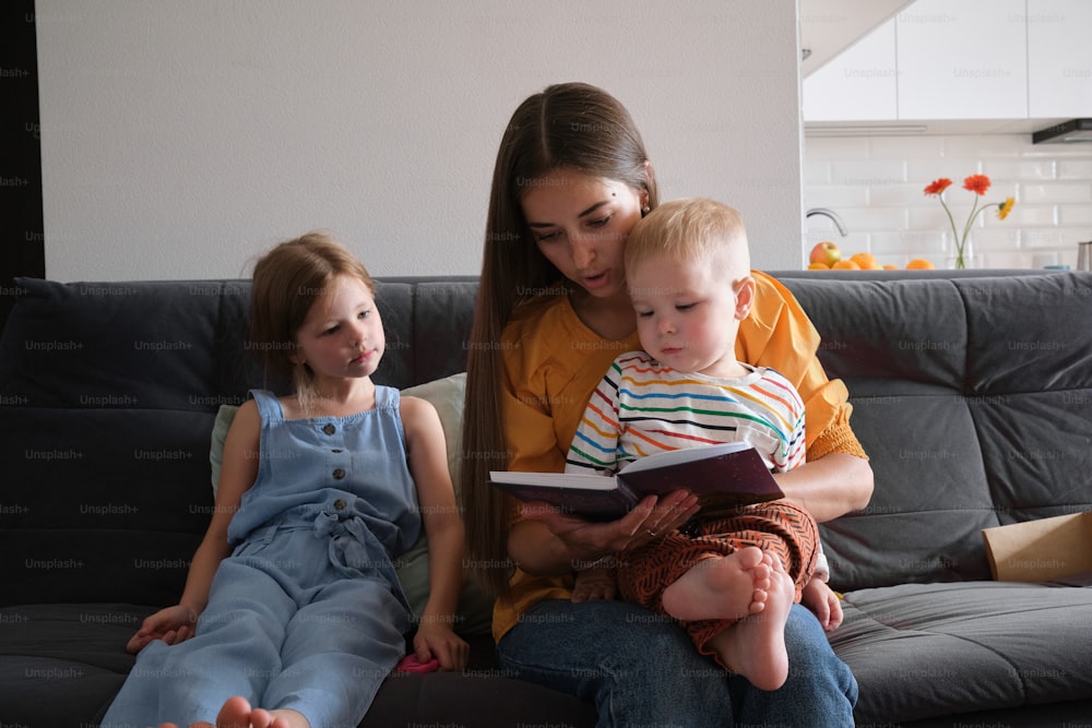 a woman reading a book to two children