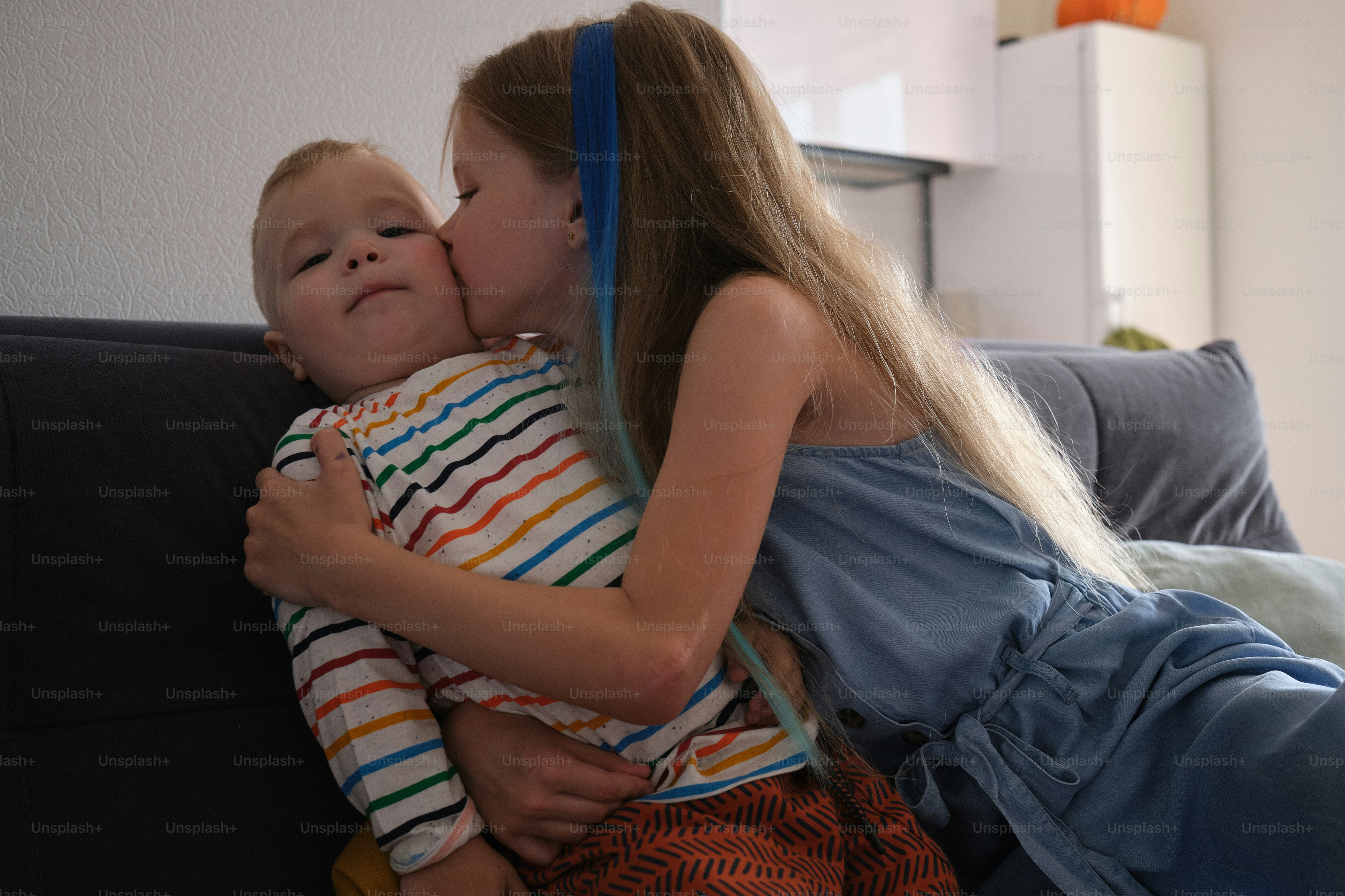 a little girl kissing a little boy on the cheek