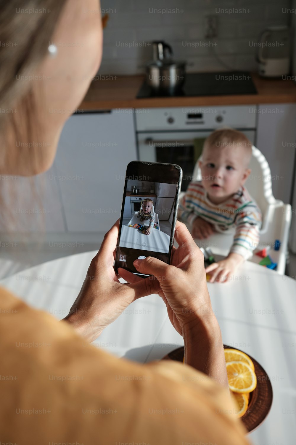 a woman taking a picture of a baby on her phone