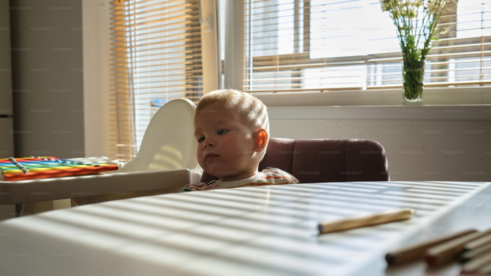 un bambino piccolo seduto a un tavolo con un libro