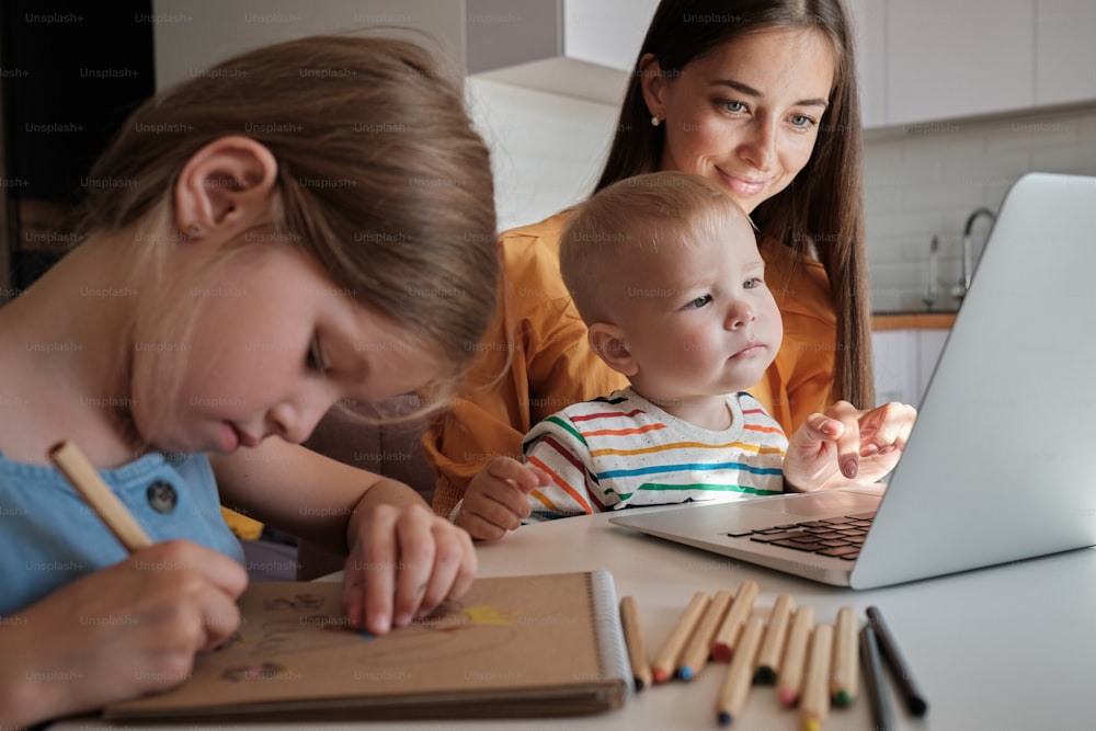 a woman and a child are looking at a laptop