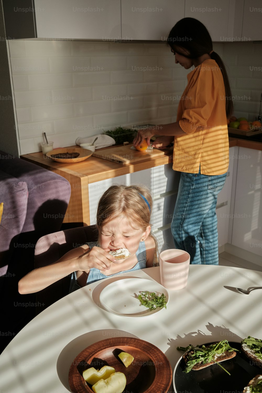 식탁에 앉아 음식을 먹는 어린 소녀