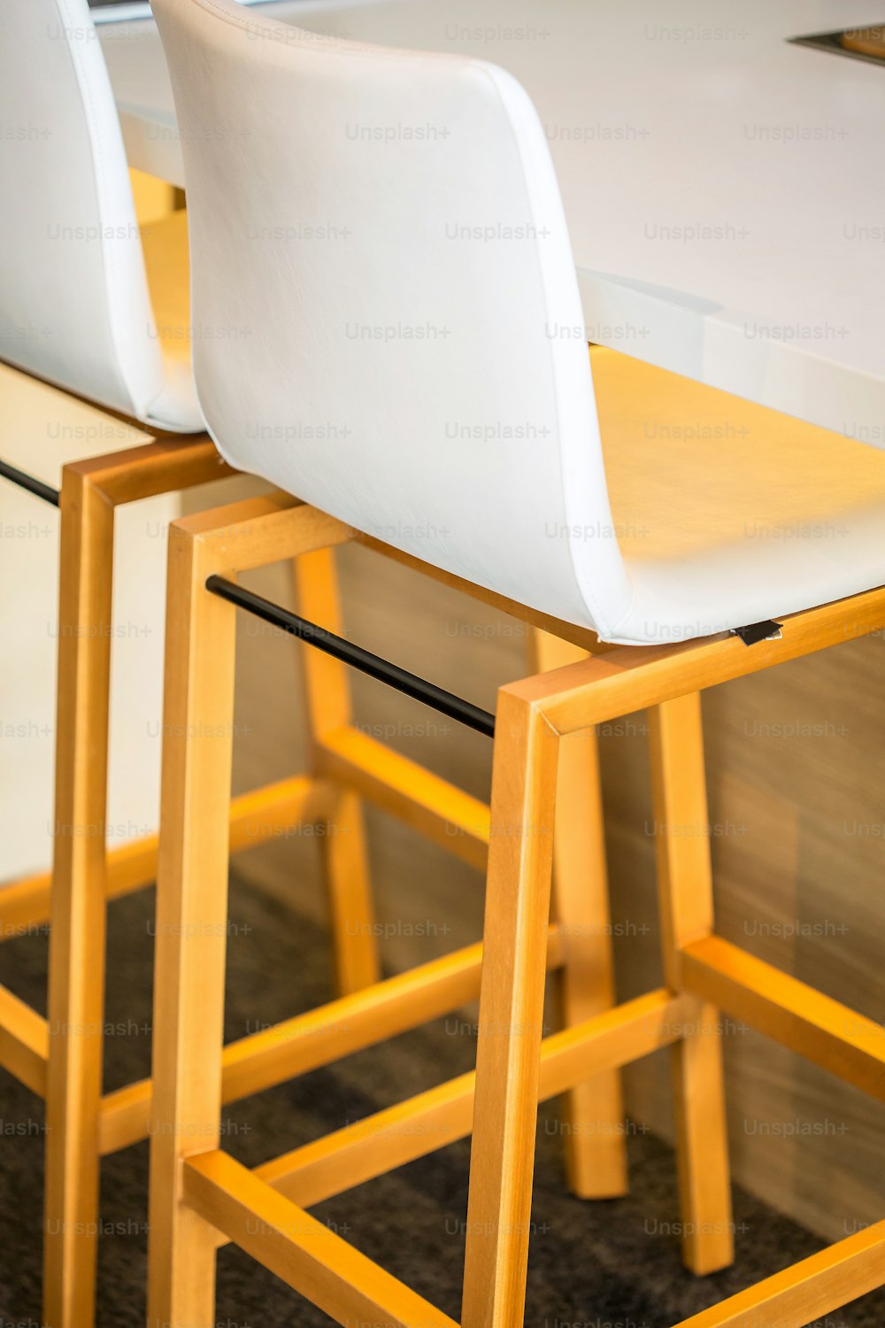 a close up of a bar stool with a table in the background