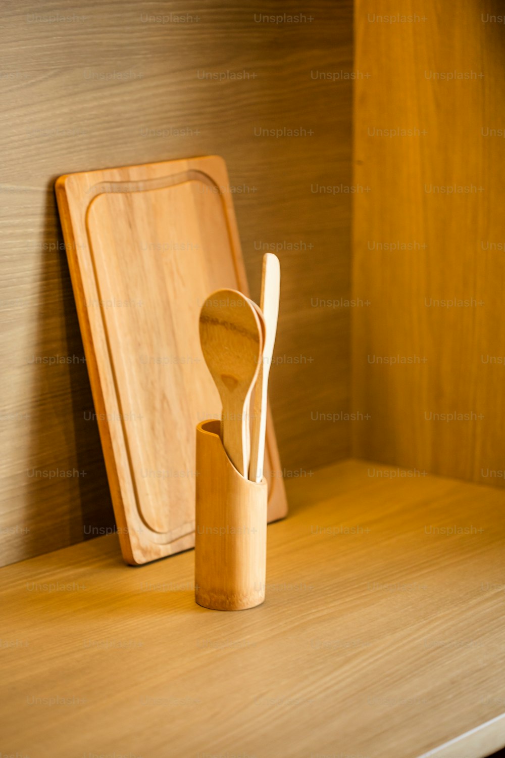 una cuchara de madera y un portacucharas de madera en un estante