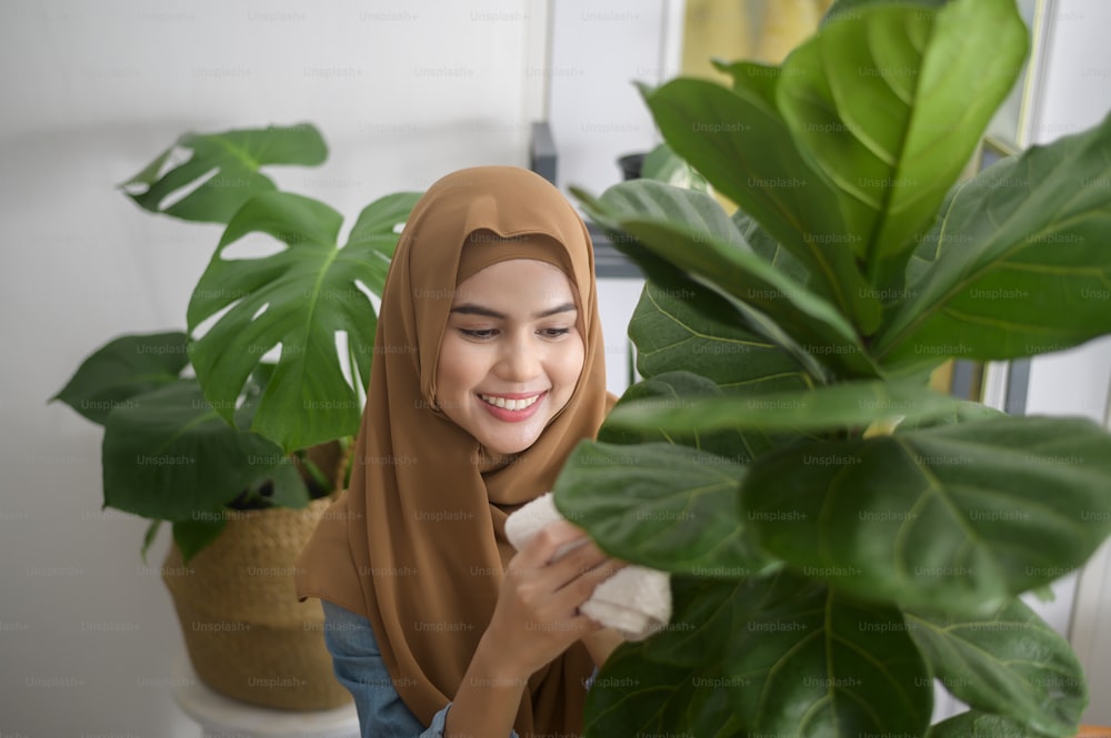Une jeune femme musulmane heureuse appréciant et relaxant l’activité de loisirs dans le jardin à la maison