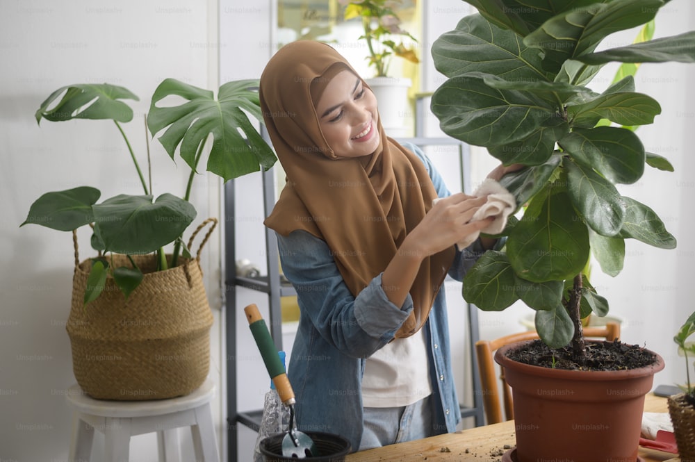 Eine glückliche junge muslimische Frau, die die Freizeitgestaltung im Garten zu Hause genießt und entspannt