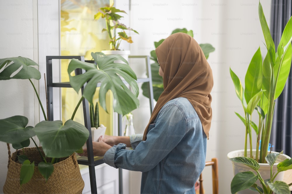 Eine glückliche junge muslimische Frau, die die Freizeitgestaltung im Garten zu Hause genießt und entspannt