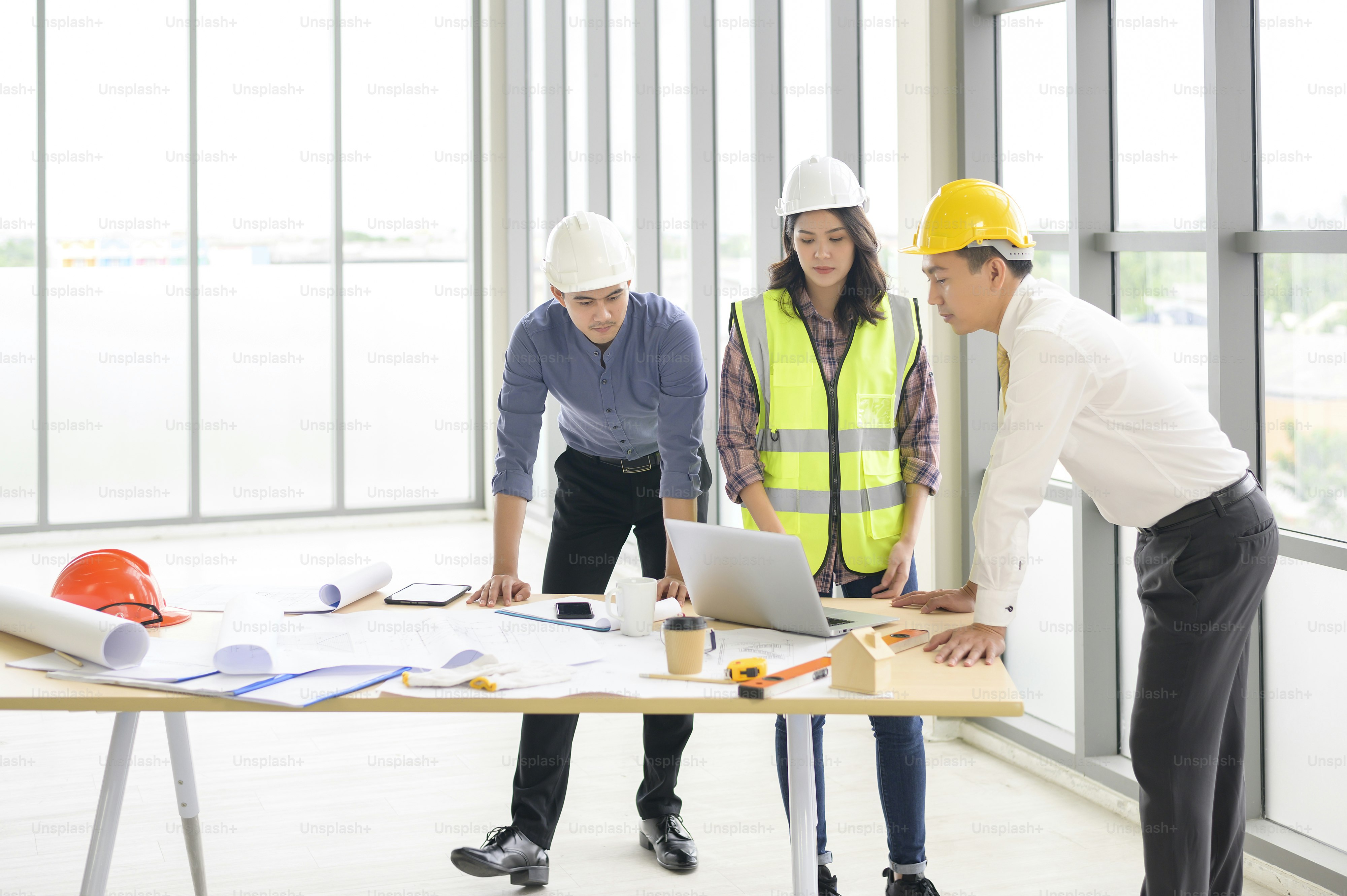 Le persone di ingegneria sono piani di costruzione analitici con progetto in ufficio.