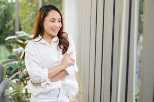 Un retrato de una mujer asiática de negocios segura de sí misma con camisa blanca en la oficina