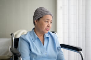 Una donna asiatica malata di cancro depressa e senza speranza che indossa il velo in ospedale.