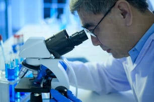 Un scientifique utilisant un microscope lors d’une expérience en laboratoire, concept de soins de santé de la science et de la technologie