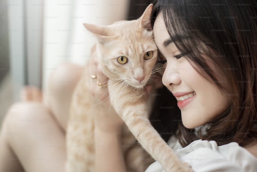 Beautiful asian  cat lover woman is playing with cat in her room