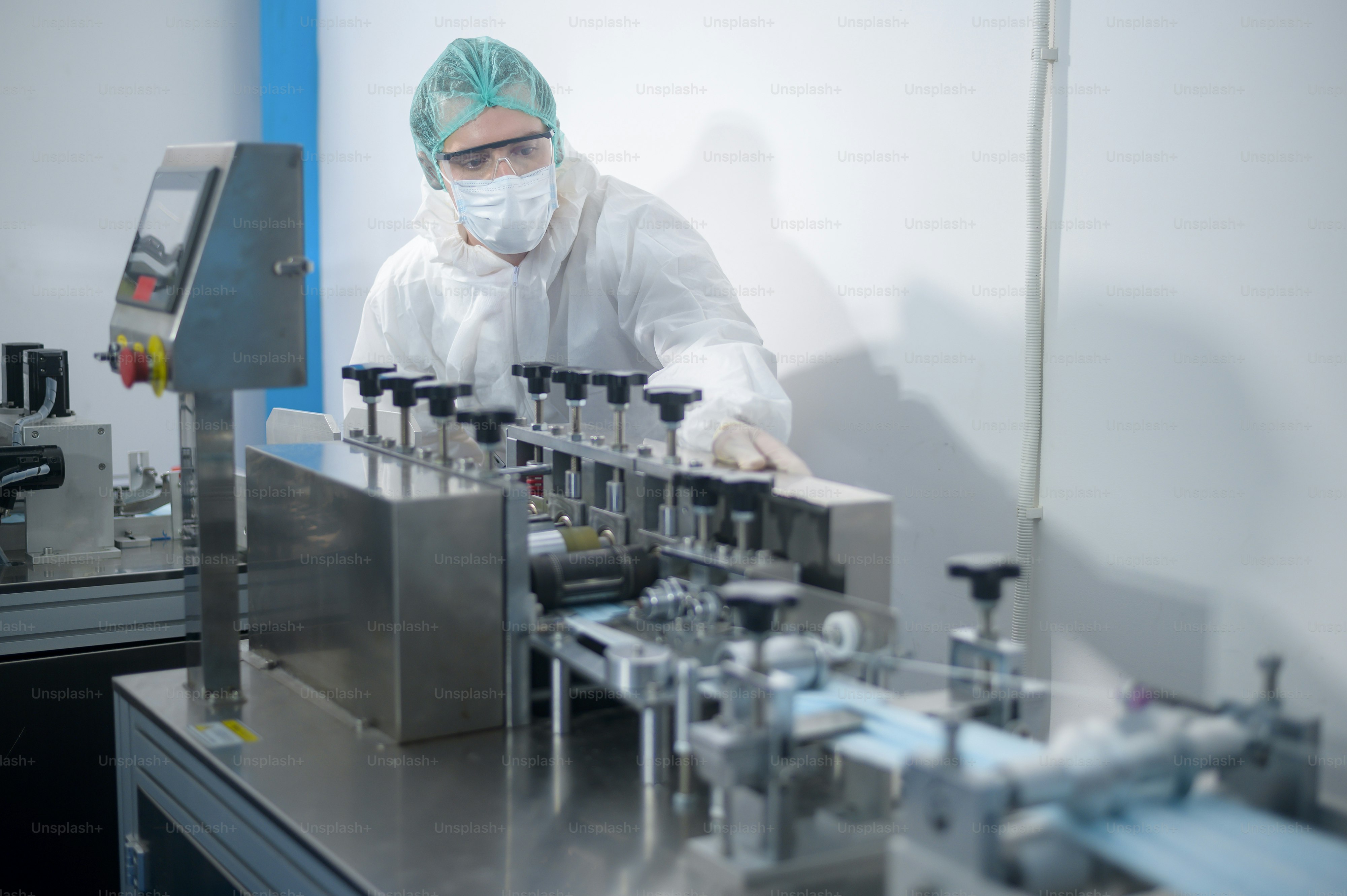 Workers producing surgical mask in modern factory, Covid-19 protection and medical concept.