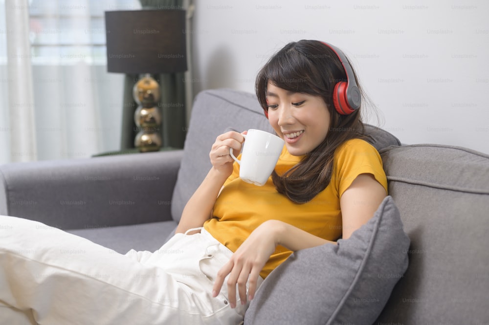 Une jeune femme heureuse écoutant de la musique et se relaxant à la maison