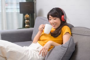 Una giovane donna felice che ascolta musica e si rilassa a casa