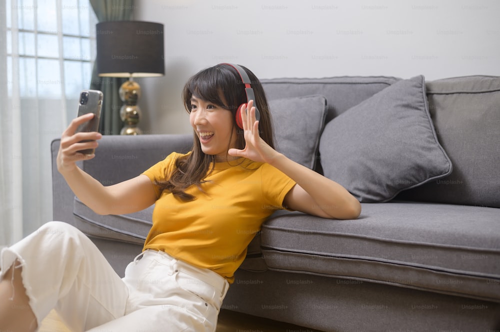 Une jeune femme heureuse écoutant de la musique et se relaxant à la maison