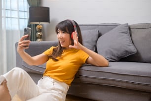 A young happy woman listening to music and relaxing at home