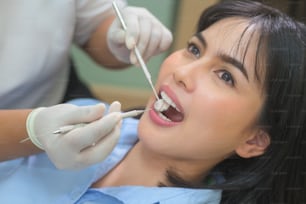 치과 진료소에서 치과 의사가 치아를 검사하고 치아 검진을 받고 건강한 치아 개념을 가진 젊은 여성