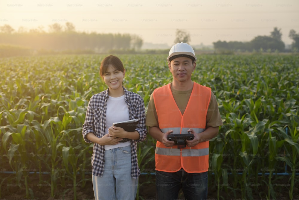 A male engineer  provide a consultation and instructing to smart farmer with drone spraying fertilizer and pesticide over farmland,High technology innovations and smart farming