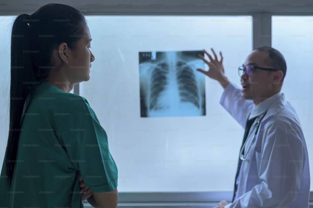 Der Arzt ist analytischer Röntgenfilm, der dem Patienten zeigt, Gesundheitskonzept
