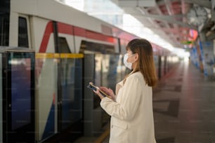 Una giovane donna indossa una maschera protettiva in metropolitana, protezione covid-19, viaggi di sicurezza, nuova normalità, distanziamento sociale, trasporti di sicurezza, viaggi in regime di pandemia