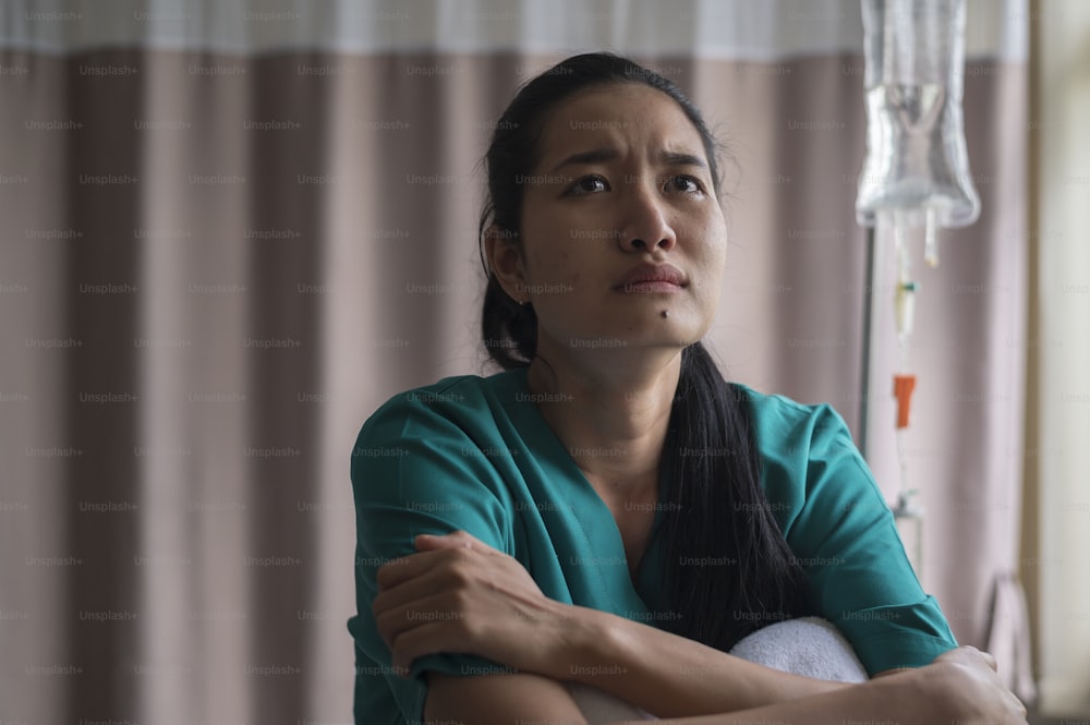 Una paciente asiática abatida. Tras la declaración del médico de que el cáncer se acercaba al final de su curso.