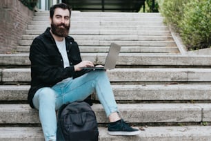 a man sitting on steps with a laptop
