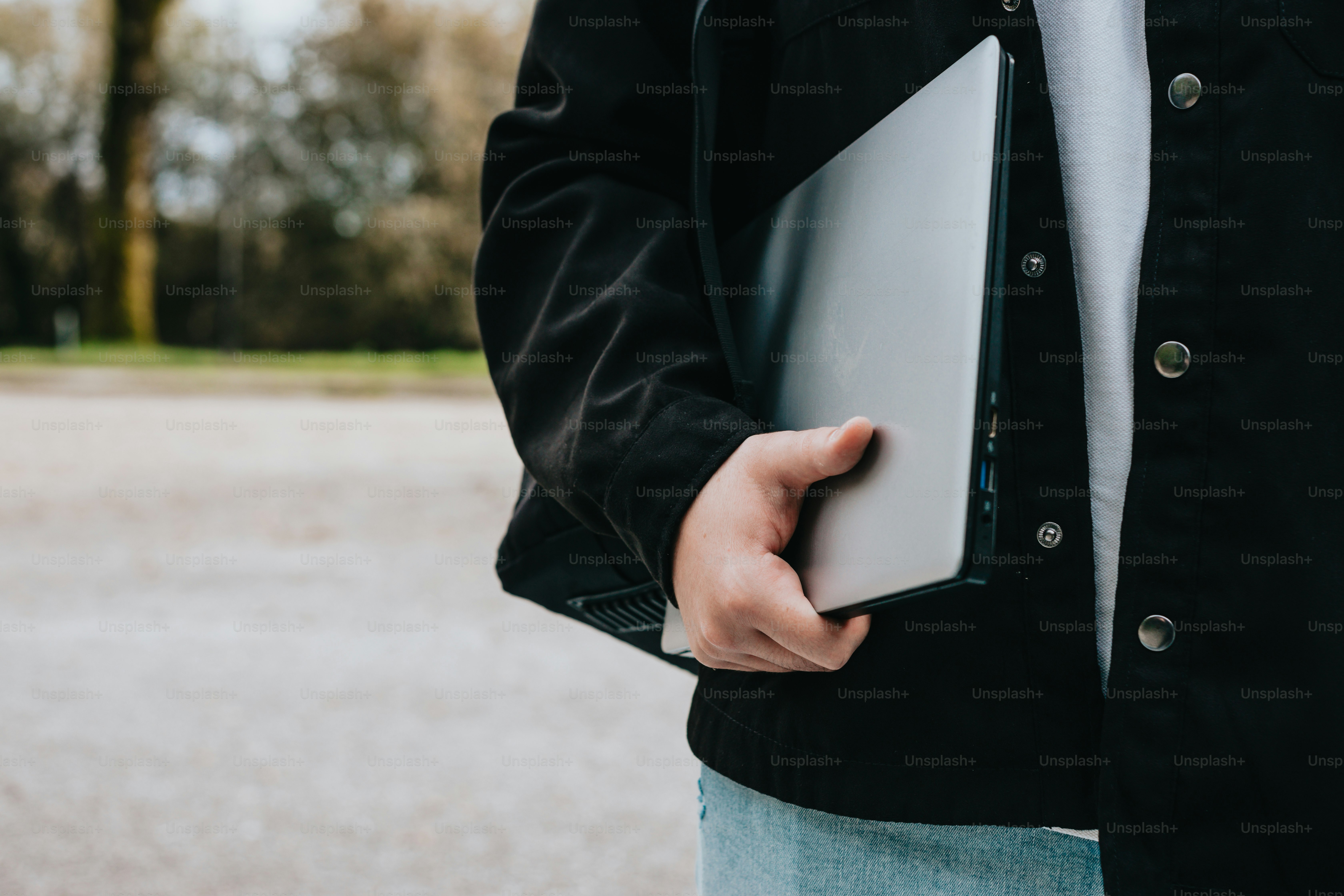 uma pessoa segurando um laptop em suas mãos