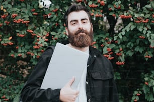 Un hombre con barba sosteniendo una carpeta