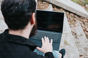 a man sitting on the ground using a laptop computer