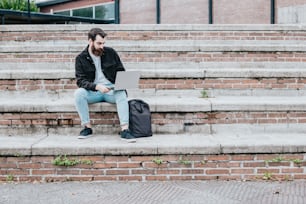 a man sitting on steps using a laptop