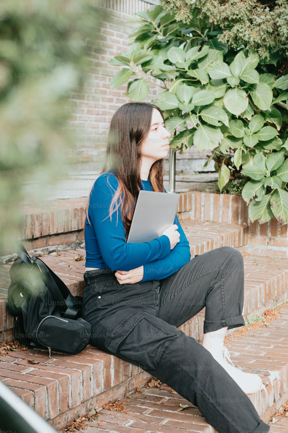 a woman sitting on steps with a laptop