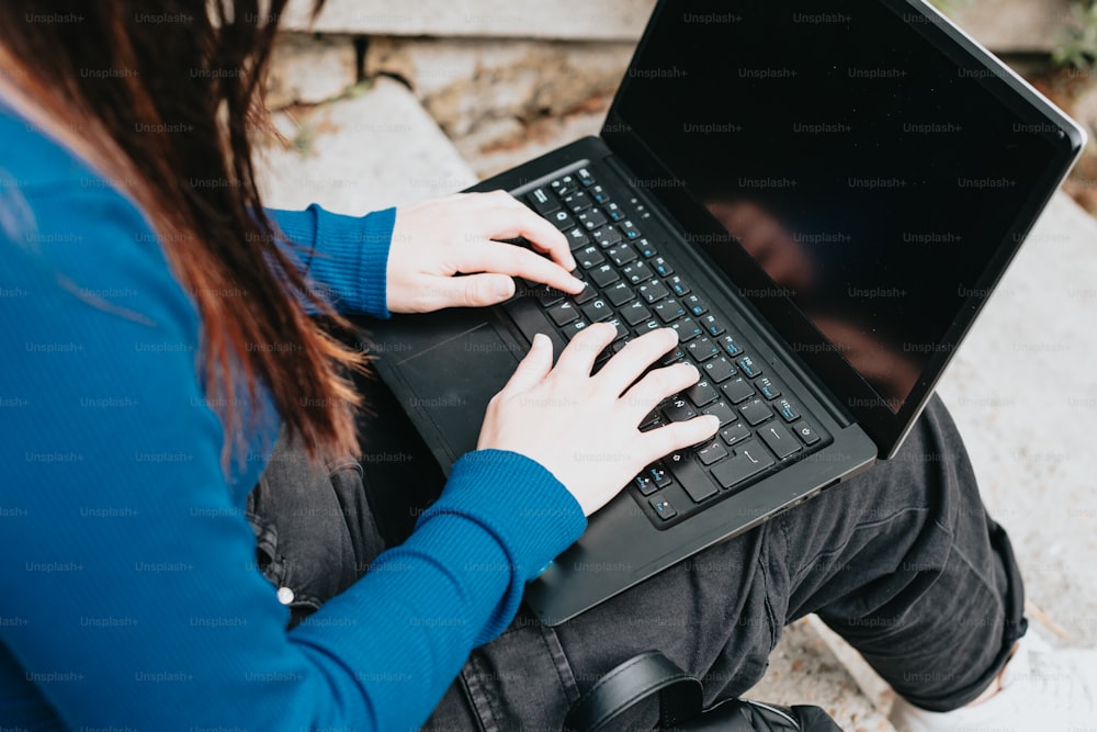노트북 컴퓨터를 사용하여 바��닥에 앉아 있는 여자