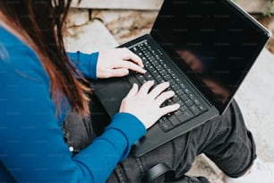 a woman sitting on the ground using a laptop computer