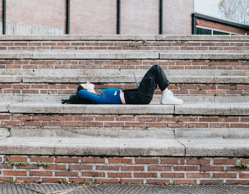 a person laying on the steps of a building
