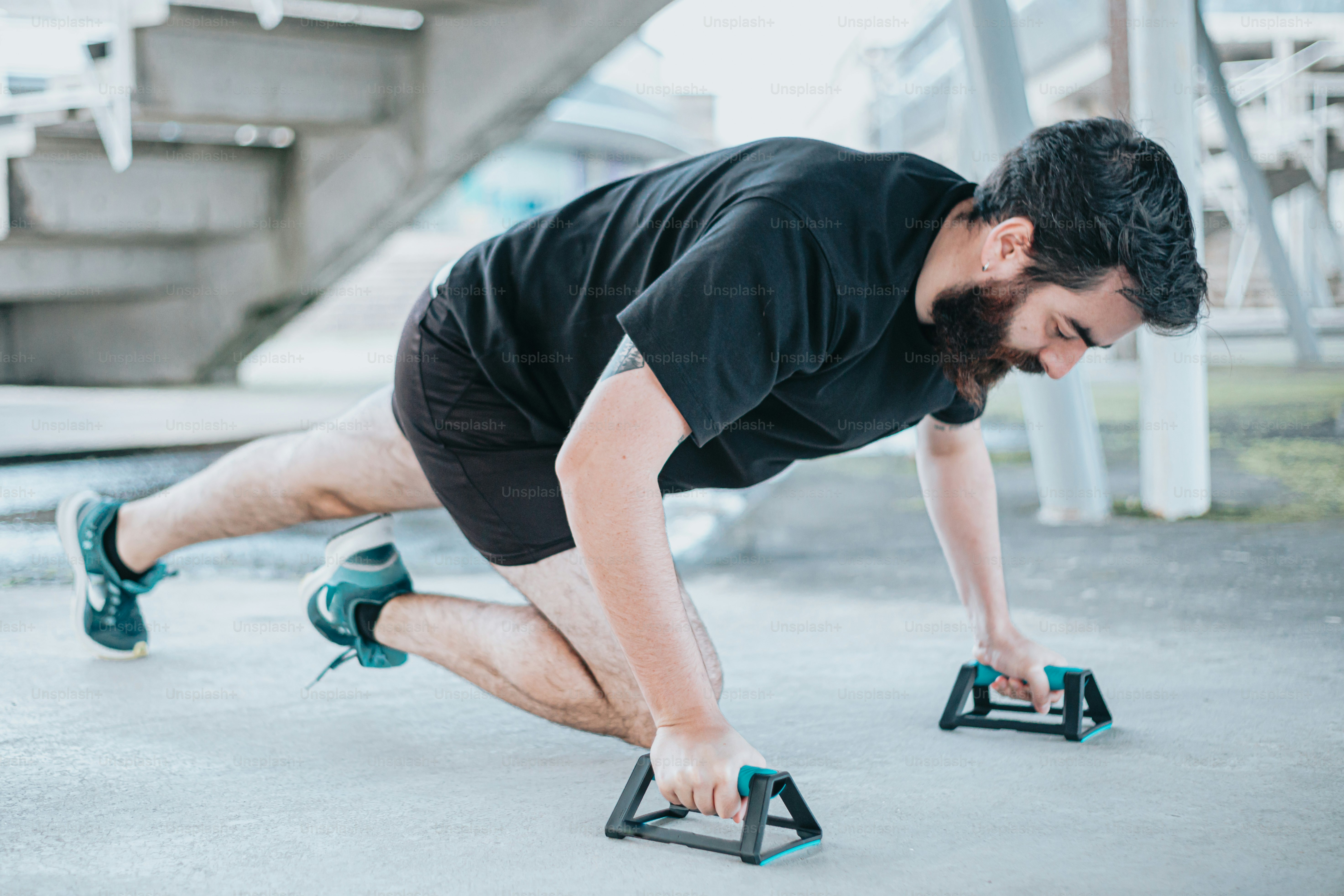 Seorang pria sedang melakukan push up dengan sepasang sepatu